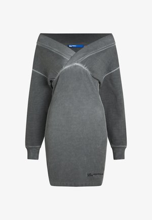 Siva oversize obleka z globokim V-izrezom, dolgimi rokavi in ribastimi manšetami. Narejena iz mehkega blaga z rahlo teksturirano površino. Vključuje podrobnost z logotipom.