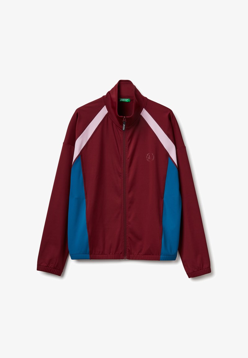 Chaqueta atlética marrón con paneles blancos y azules. Presenta un cuello alto, cremallera frontal completa y un pequeño logo en el pecho. Textura suave.