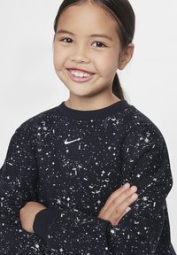 Felpa nera con motivo a pois bianchi e piccolo logo Nike sul petto. Collo rotondo e polsini a costine. Tessuto morbido.