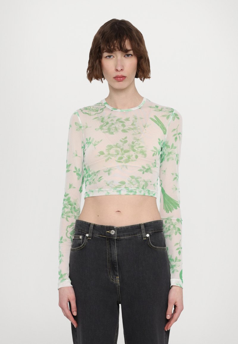 Langermet cropped topp laget av gjennomsiktig stoff med grønt blomsterprint; har rund hals og tettsittende silhuett. Kombinert med mørke jeans.