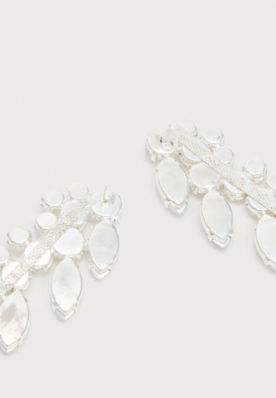 Σκουλαρίκια σε ασημί απόχρωση με στρογγυλές και μαρκίζες ανακλαστικές πέτρες διατεταγμένες σε σχέδιο βεντάλιας σε λευκό φόντο.