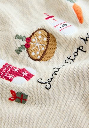Knit blanket featuring cream-colored fabric, embroidered designs of Christmas stockings, a pie, milk bottle, and a wrapped gift.