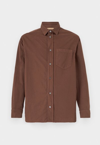 Chemise brune à boutons avec un col, des manches longues, une poche poitrine unique et des boutons gris, fabriquée à partir d'un tissu texturé.