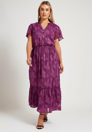 Lila Maxikleid mit kurzen Schmetterlingsärmeln, strukturiertem Blumenmuster, Knopfverschluss vorne und elastischem Taillenbund. Geschichteter Rüschensaum am unteren Ende.