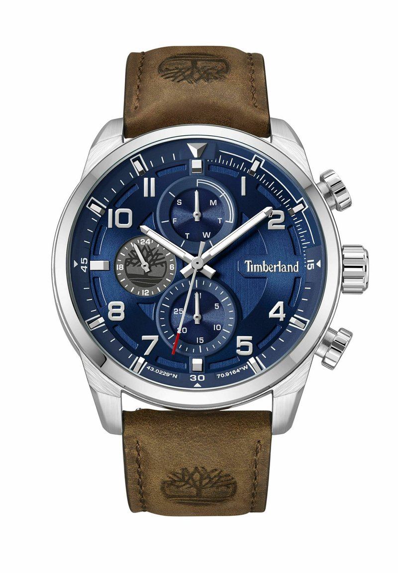 Timberland pulkstenis ar zilu ciparnīcu, nerūsējošā tērauda korpusu, hronogrāfa funkcijām, brūnu ādas siksniņu un logo, kas iepresēts siksniņā.