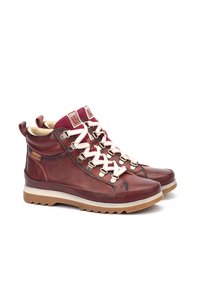 Bottes de randonnée en cuir marron avec des accents en textile bordeaux, des lacets blancs et une semelle en caoutchouc robuste dotée d'un motif texturé pour une meilleure adhérence.