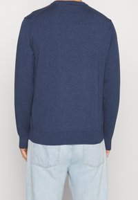 Dunkelblauer Strickpullover mit Rundhalsausschnitt und gerippten Ärmelbündchen. Verfügt über einen strukturierten Stoff und eine taillierte Passform. Rückansicht gezeigt.