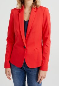 Red tailored blazer featuring a single button closure, notch lapels, and two front pockets, made from a smooth fabric with a structured fit.