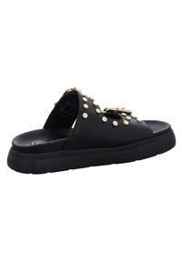 Sandales à semelle plate noires avec studs dorés, design à bout ouvert, dessus synthétique lisse et semelle en caoutchouc texturée. Comprend un détail de boucle décorative.