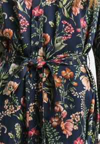 Dunkelblaues Kleid aus floral gemustertem Stoff mit Knöpfen, einem taillierten Bund und einer Mischung aus rosa, orange und grünen Blumendesigns.