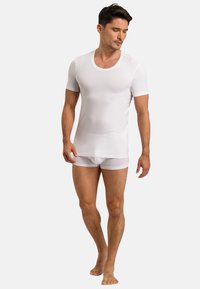 White short-sleeve t-shirt made from a smooth, lightweight fabric, paired with white fitted shorts. Simple design with a round neckline.