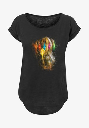 Sort kortærmet t-shirt med et farverigt grafik af en handske-klædt næve prydet med livlige ædelstene, sat mod en struktureret baggrund.