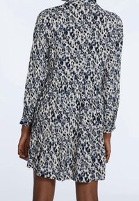 Leopardmuster-Kleid in Beige und Marineblau, mit langen Ärmeln, einem Kragen und einem Stufensrock mit gerafftem Detail an der Taille.