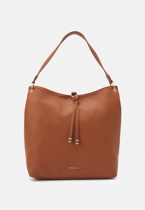 Brązowa skórzana torba na ramię z pojedynczym paskiem, zamknięciem na sznurek i subtelnymi elementami w złotym odcieniu na jednolitym tle.