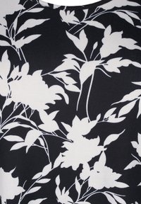 Tessuto nero con un motivo floreale bianco che presenta foglie e fiori dettagliati. La texture appare liscia e leggermente elasticizzata.