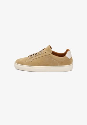 Sneaker beige in camoscio low-top con suola in gomma bianca, fodera interna color cuoio, lacci beige e toppa bianca sul tallone, vista laterale.