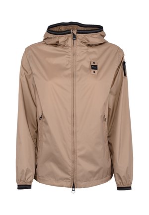 Giacca beige leggera con cappuccio, zip frontale, due tasche laterali con zip, polsini elasticizzati e toppe con logo nero sul petto e sulla manica.