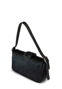 Borsa nera con superficie morbida e pelosa dalla texture evidente. Presenta una chiusura decorativa con dettagli neri e una lunga tracolla regolabile in pelle.