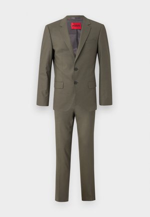 Olive green suit with a two-button jacket, notch lapels, and flat-front trousers. Features a red branded tag inside the jacket. Smooth texture.