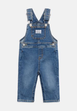 Blue denim toddler overalls with adjustable shoulder straps, front chest pocket, side buttons, and visible orange stitching.
