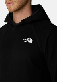 Felpa nera con cappuccio realizzata in morbido tessuto, dotata di una tasca frontale a marsupio e un logo ricamato bianco sul lato sinistro del petto.