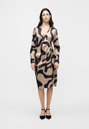 Rochie petrecută din amestec de mătase, bej cu un model abstract negru. Prevăzută cu mâneci lungi, decolteu în V și detaliu cu cordon la talie. Pantofi cu toc.