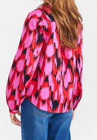 Camicia a maniche lunghe con un motivo astratto in rosa, rosso e nero, caratterizzata da una vestibilità rilassata e polsini con bottoni, realizzata in un tessuto liscio.