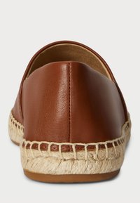 Hnědá kožená slip-on bota s zaobleným zadním dílem a pletenou jutovou podrážkou. Hladká textura s minimem švů.