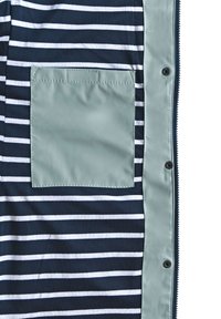 Striped textile featuring navy and white stripes with a mint green, smooth pocket and zipper detail. The fabric appears soft and lightweight.