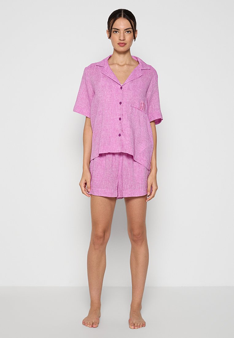 Różowy zestaw piżam z lnu, składający się z krótko rękawowej koszuli zapinanej na guziki z kieszonką z przodu i dopasowanych szortów; lekki, luźny krój.