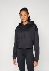 Black cropped hoodie with a drawstring and embossed "NIKE PRO" logo on the front; worn with black leggings featuring a small Nike logo.