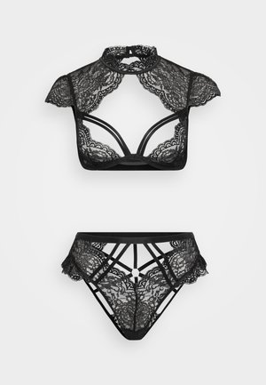 Conjunto de lencería de encaje negro que incluye una parte superior estilo collar con recortes y mangas cortas, combinado con una parte inferior con tiras y detalles.