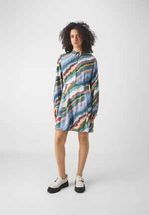 Robe chemise à manches longues en tissu bleu clair avec des motifs ondulés multicolores. Finition avec une fermeture à boutons devant et une taille cintrée.