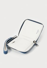 Navy blue wallet with a textured exterior, white interior, zip closure, multiple card slots, and a detachable wrist strap.