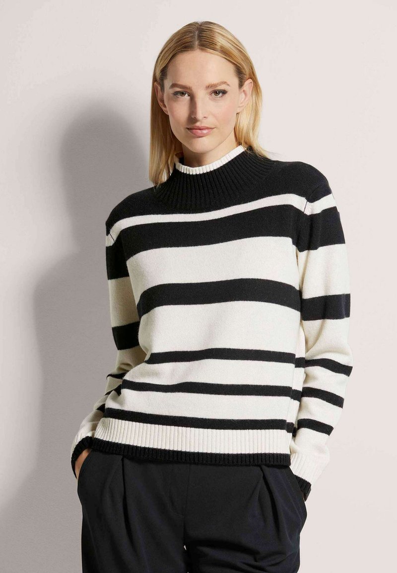 Gestreifter Pullover in Schwarz und Weiß mit hohem, geripptem Kragen und gerippten Bündchen, aus weichem Strickmaterial. Lockere Passform.