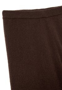 Dark brown knitted fabric with ribbed waistband, showing soft texture and elastic stretch at the top edge.