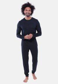 Marineblauw longsleeve shirt met een borstzak en bijpassende broek. De stof is zacht en glad, voorzien van een elastische tailleband en manchetten.