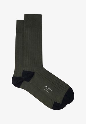 Par de calcetines acanalados de color verde oscuro con dedos y talones negros, con la marca Hackett London en la suela.