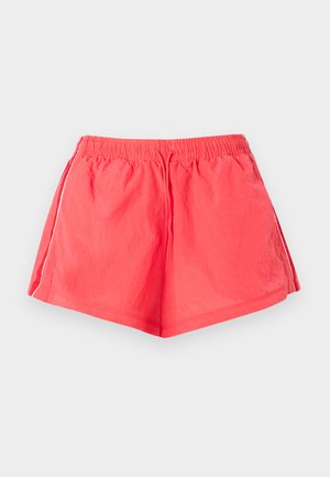 Κόκκινα αθλητικά σορτς με ελαστική μέση και κορδόνι, με λευκές ρίγες στα πλάγια, σε απλό φόντο.