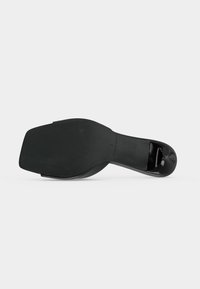 Semelle de chaussure à talon noire avec un bout carré et une petite prise texturée sur la pointe du talon, présentée sur un fond clair uni.