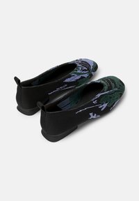Black and patterned slip-on ballet flats with green and purple designs, showcasing a low heel and textured fabric.