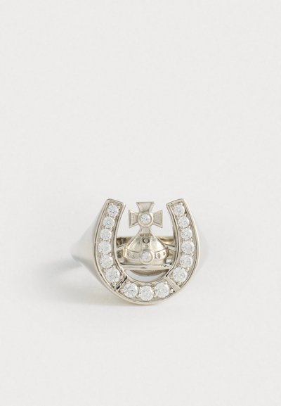 Ezüst gyűrű lópatkó mintával, a közepén kereszttel és koronával, kis, tiszta strasszokkal körülvéve.