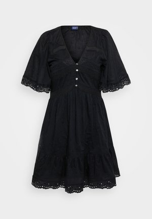 Mustmust dress lühikeste plisseeritud varrukatega, V-kaelus, dekoratiivnuppudega, tekstuuriga kangas ja broderi detailid allääril ja bodicil.