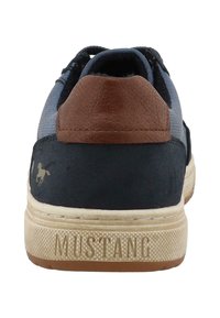 Muške tenisice s gornjim dijelom od tamnoplave tkanine, smešnim kožnim akcentima, teksturiranom gumom potplatom i "MUSTANG" oznakom na peti.