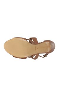 Bruine leren sandaal met meerdere straps en een gesp-sluiting. Soepele zool met ribbels voor grip en een ronde teenvorm.