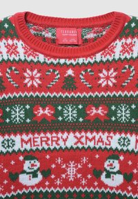 Czerwony sweter z dzianiny z wzorem białych i zielonych płatków śniegu, lasek cukrowych, choinek i bałwanków, z napisem "WESOŁYCH ŚWIĄT" w białym kolorze.