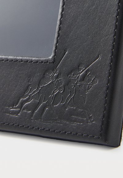 Svart lær fotoalbum med en teksturert design som har preget figurer på den ene siden og kontrasterende søm langs kanten.