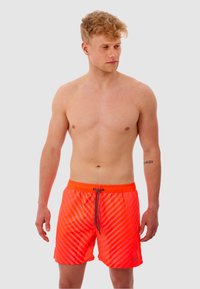 Neon oranje zwembroek met horizontale strepen, elastische tailleband en trekkoord. Gemaakt van lichtgewicht, sneldrogend materiaal.