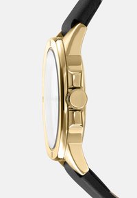 Gouden horloge met een gladde kast, een ronde glazen wijzerplaat en een zwart lederen band. Heeft een ronde kroon aan de zijkant.