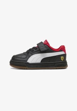 Schwarzer Sneaker mit weißem Seitenstreifen, roter Ferse und rotem Schaft, Klettverschluss, Gummisohle und gelbem Ferrari-Logo an der Seite.